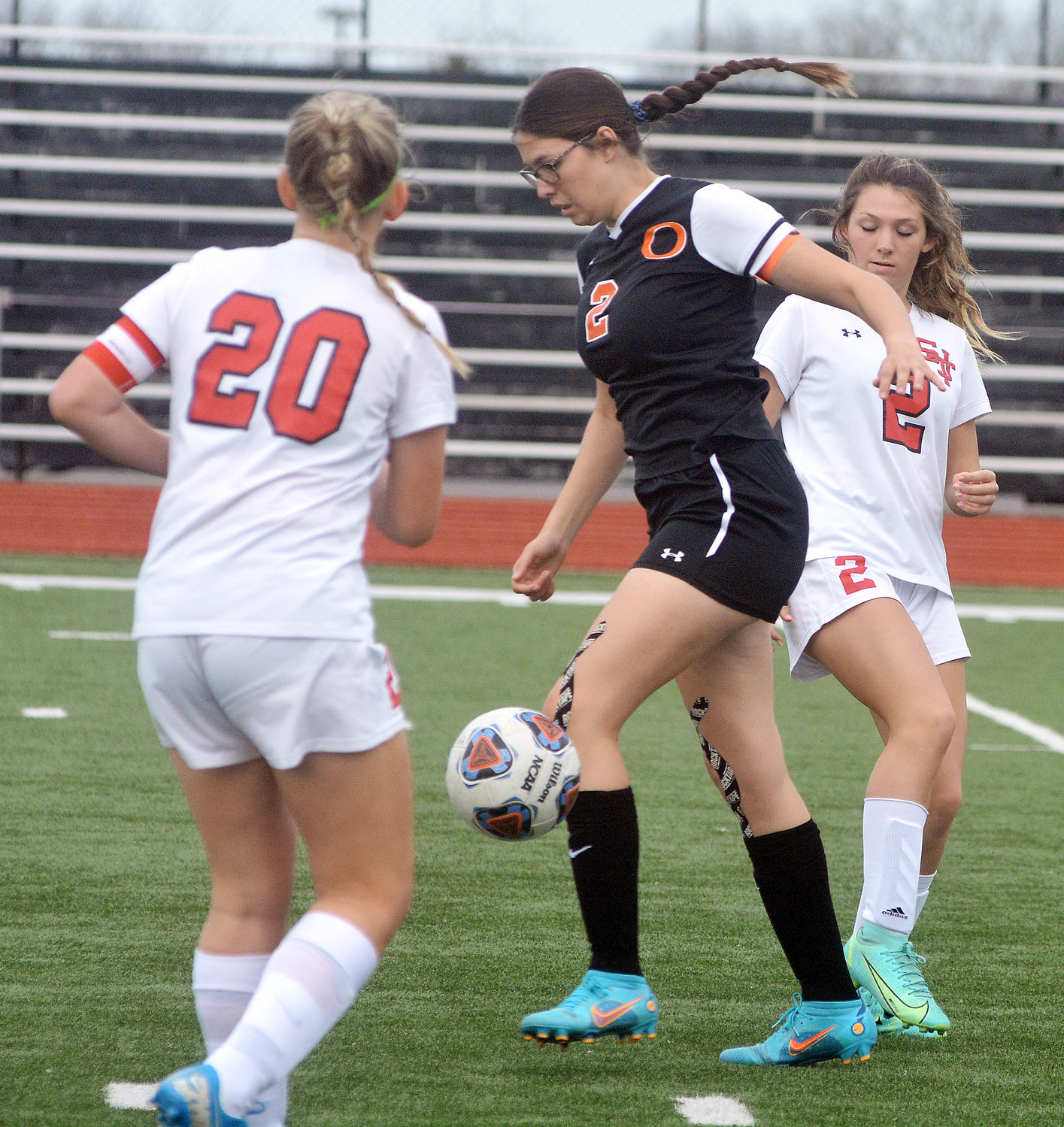 Leah Reed (center) guides the soccer ball through a pair of St. James players.